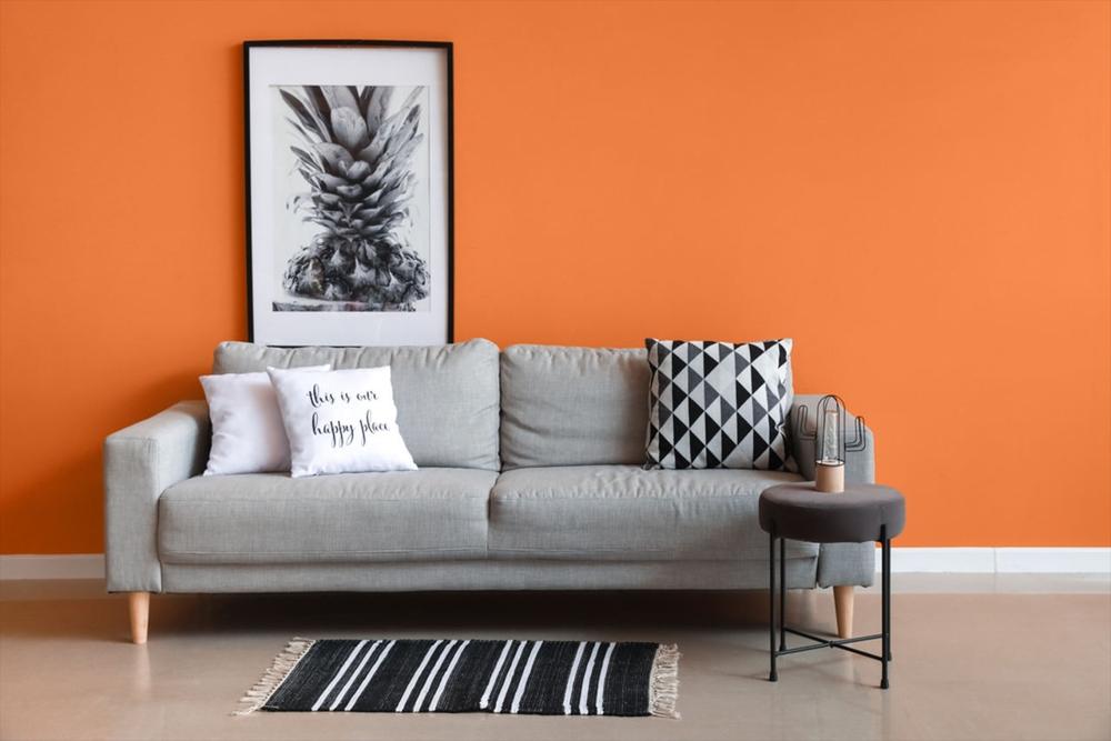 مبل خاکستری روشن و دیوار نارنجی