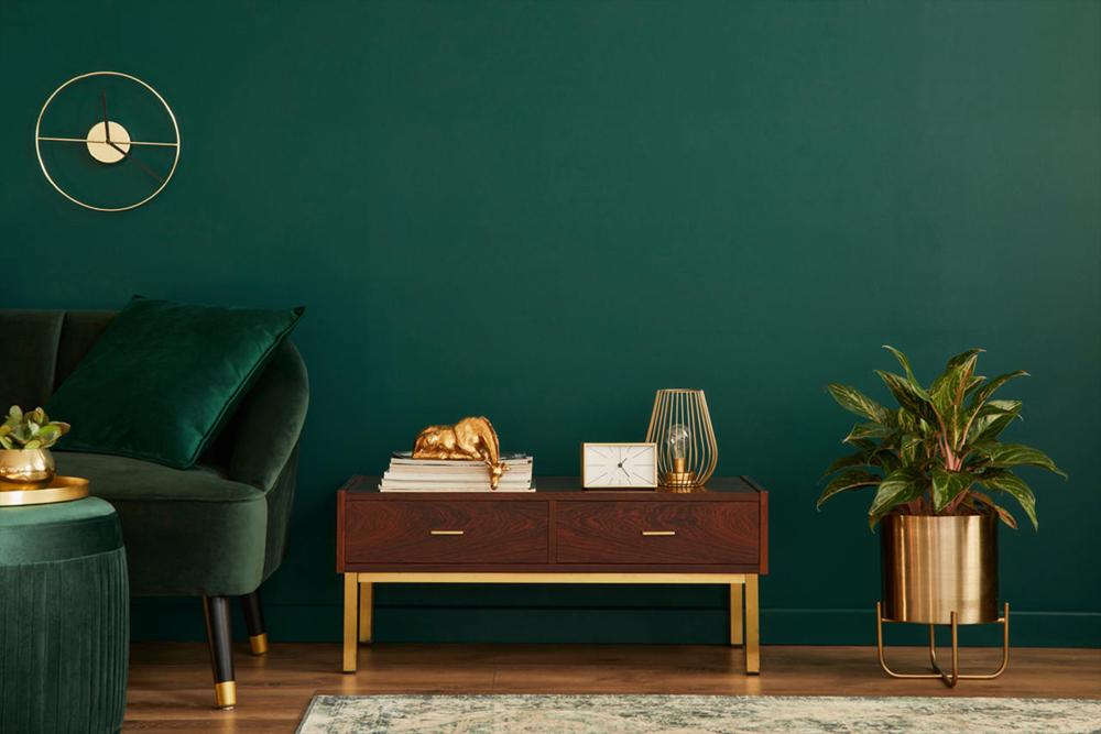 Emerald green sofa and wooden drawer at the living room