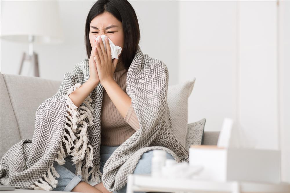 sick-woman-blowing-her-nose-at-home