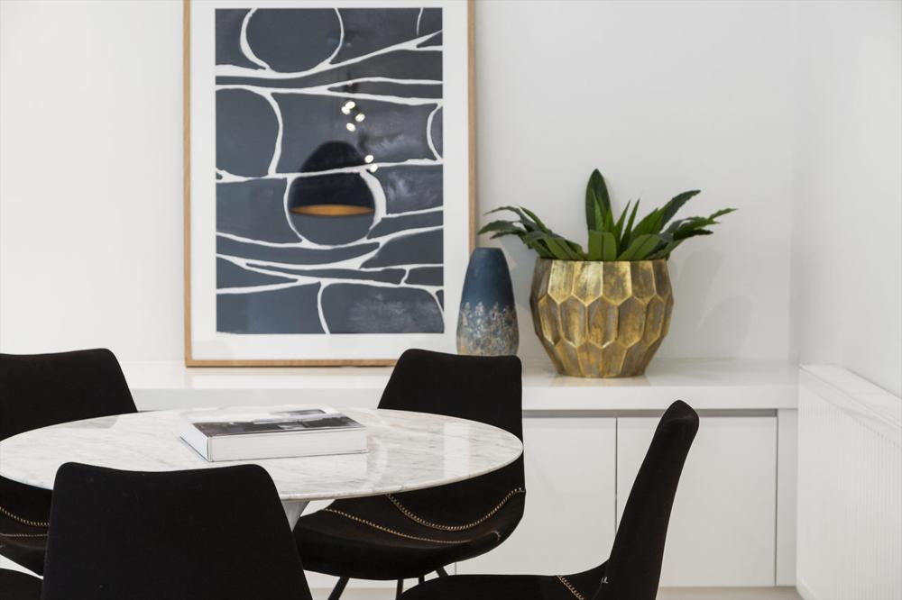 modern white round table with black chairs
