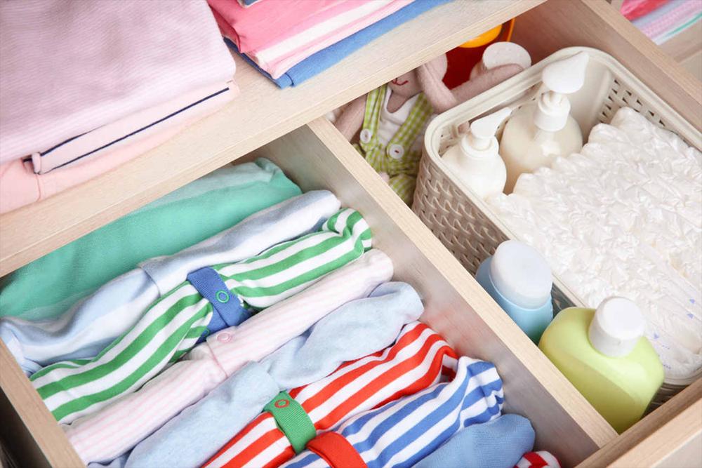 organization of baby clothes and diapers in a baby dresser