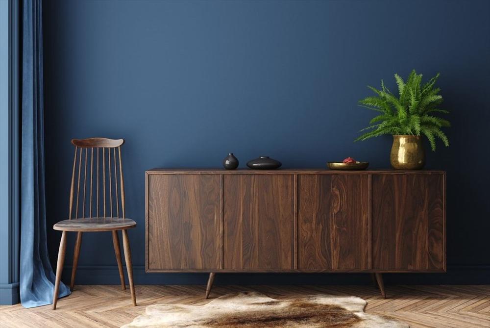dark brown sideboard at the room with dark blue wall