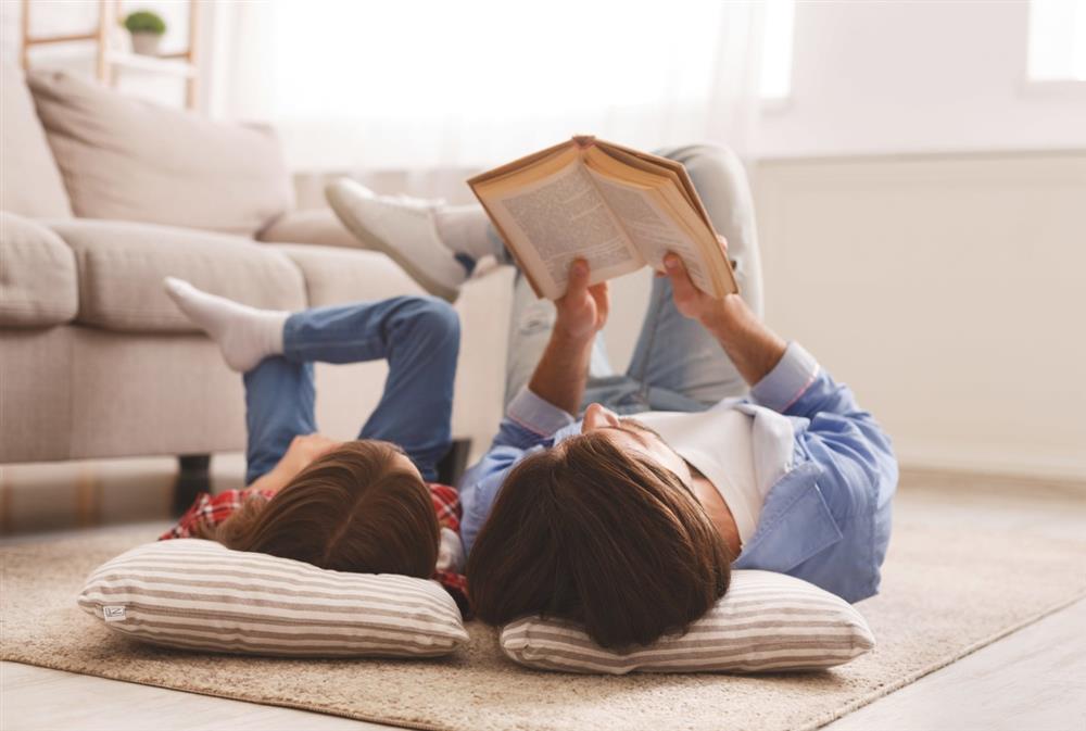 çocuğu ile yerde kitap okuyan baba
