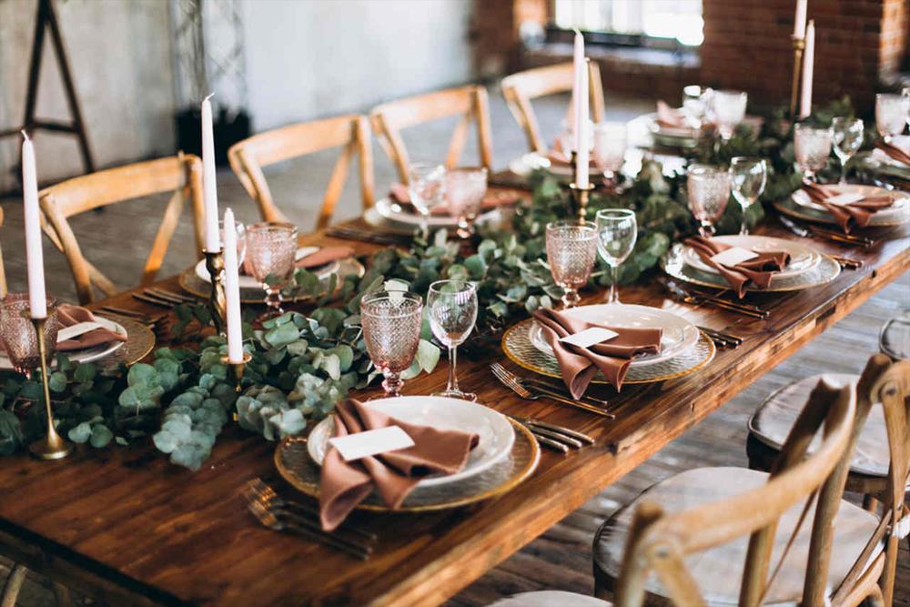 میزی پر از شمعدان های زیبا، ظروف غذاخوری و تزئینات مختلف