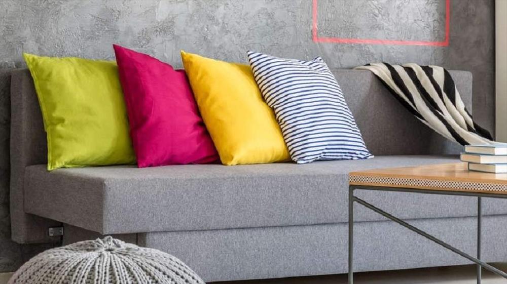 Grey sofa with colorful pillows and a striped pillow