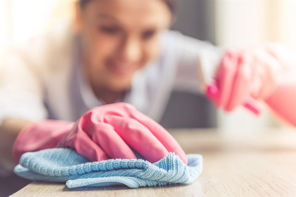 زن در حال ضد عفونی کردن خانه برای حفظ نظافت و بهداشت در خانه