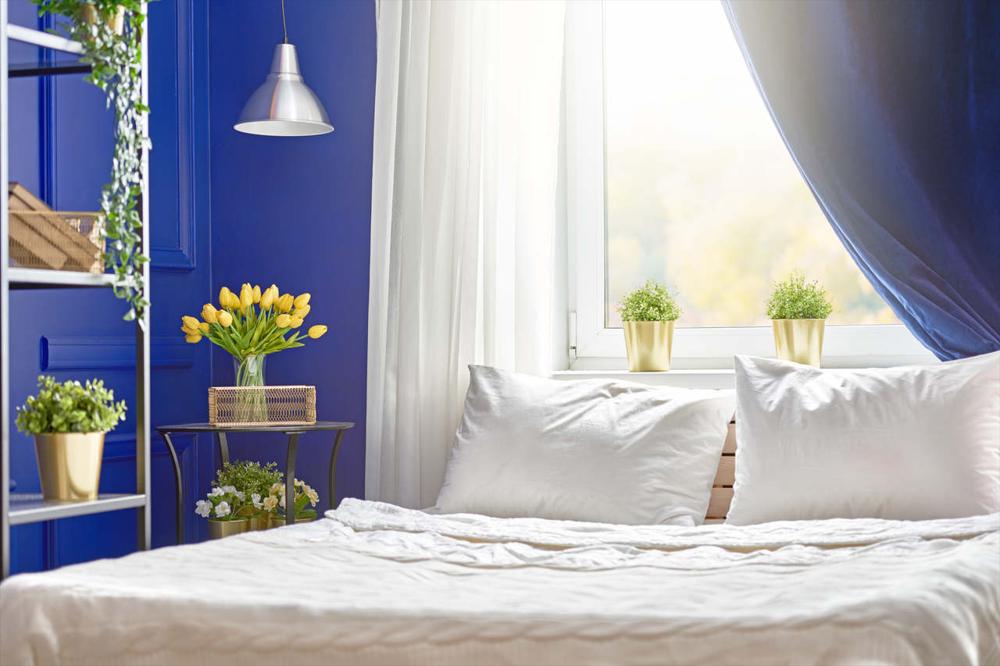 duvarları maviye boyanmış yatak odası